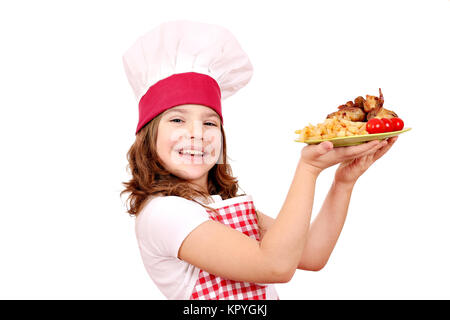 happy little girl cook with roasted chicken wings on plate Stock Photo