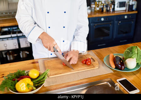 Professional  Chef Cutting Cherry Tomatoes Stock Photo