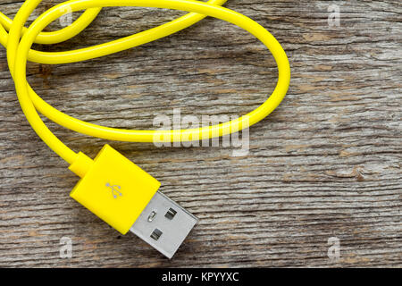 Yellow USB cable on wooden background Stock Photo