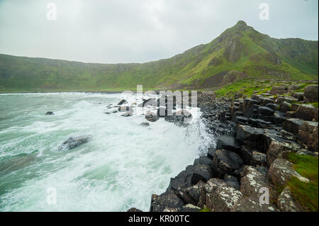 The Giant's Causeway with waves crushing on the famous basalt columns, the result of an ancient volcanic eruption. County Antrim on the north coast of Stock Photo