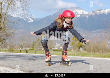 preteen girl on roller skates in helmet at track Stock Photo