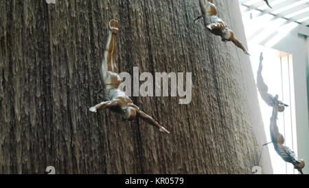 DUBAI, UAE - MAY 2, 2017: Famous Waterfall in Dubai Mall. A diver at The Waterfall inside the Dubai Mall. World's largest shopping mall. Fiberglass sculptures of human divers. Stock Photo