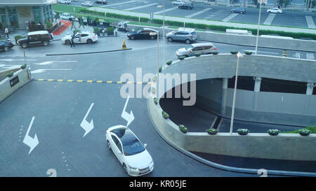Cars in a roundabout in a high view. Traffic on the roundabout. Cars driving on a circular motion in the evening Stock Photo