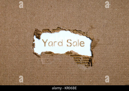 The word yard sale appearing behind torn paper. Stock Photo