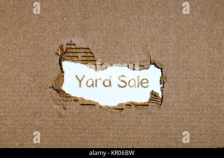 The word yard sale appearing behind torn paper. Stock Photo