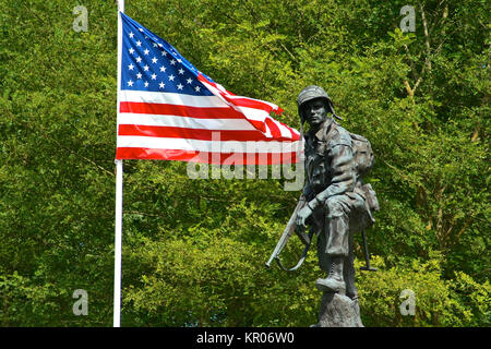 Bronze statue of an Iron Mike, a soldier of the American Army holding a gun with a flag of the United States of America. La Fiere Bridge, Sainte-Mere- Stock Photo