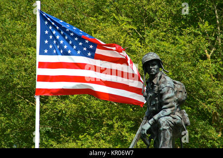 Bronze statue of an Iron Mike, a soldier of the American Army holding a gun with a flag of the United States of America. La Fiere Bridge, Sainte-Mere- Stock Photo