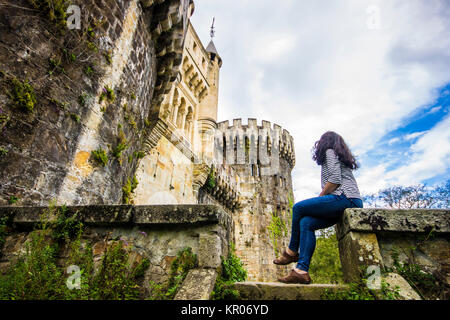 A young woman looks at the Butroeko gaztelua or Butron Castle, a fortress located in Gatika, Basque Country, northern Spain Stock Photo