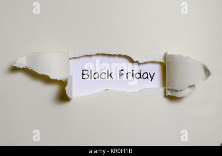 The word black friday appearing behind torn paper Stock Photo