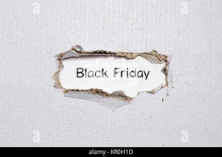 The word black friday appearing behind torn paper Stock Photo