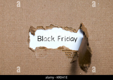 The word black friday appearing behind torn paper Stock Photo
