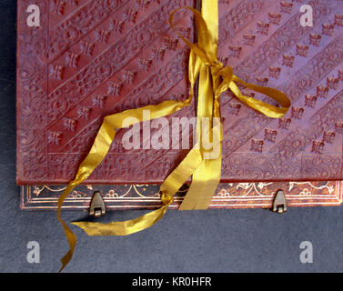 bound notebook in leather and tied with a gold ribbon Stock Photo