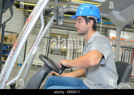 Profile of man driving forklift truck Stock Photo