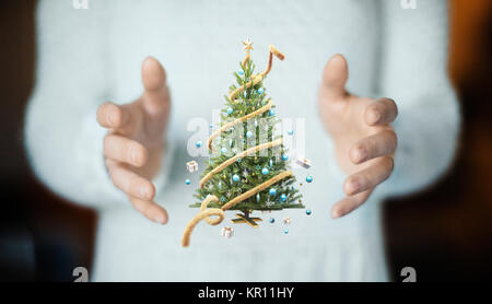 Christmas tree on hand, decorations, gift card Stock Photo