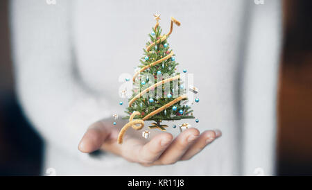 Christmas tree on hand, decorations, gift card Stock Photo