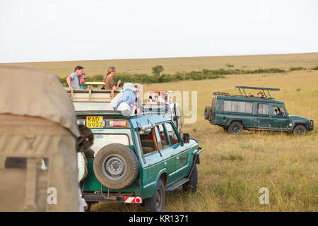 Tourists in safari vehicles on the savannah of the Masai Mara, Kenya Stock Photo