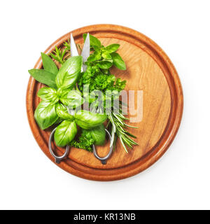 Kitchen herbs on cutting board. Fresh basil, parsley, peppermint, rosemary and scissor. Single object isolated on white background clipping path included. Top view, flat lay Stock Photo