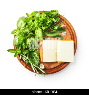 Herbs on cutting board. Fresh basil, parsley, sage, peppermint, rosemary bunch and recipe book. Single object isolated on white background clipping path included. Copy space, top view, flat lay Stock Photo