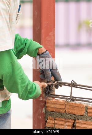 Workers using steel wire and pincers rebar before concrete is poured Stock Photo