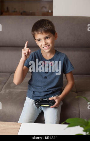 Boy sitting on couch playing video games Stock Photo