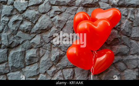 Red balloon heart on a background of gray stone.  Stock Photo