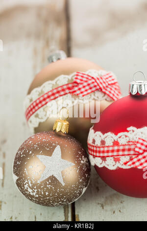 Dekorierte Weihnachtskugeln auf einem rustikalen Holzbrett zur Weihnachtszeit mit Textfreiraum Stock Photo