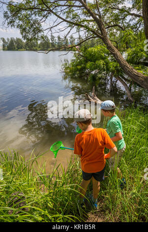 Funny happy little kid fishing on weekend. A fisherman boy stands in the  lake with a fishing rod and catches fish Stock Photo - Alamy