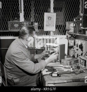 1950, historical, a male technician testing 'Ever Ready' batteries and radio valves at a workbench, England, UK. Stock Photo