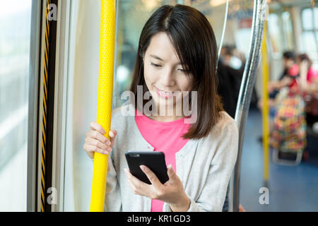 Woman using cellphone inside compartment Stock Photo
