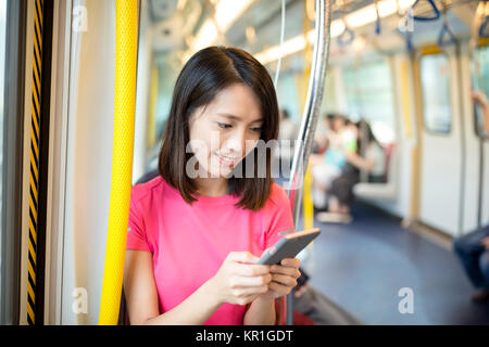 Woman use of cell phone inside train compartment Stock Photo