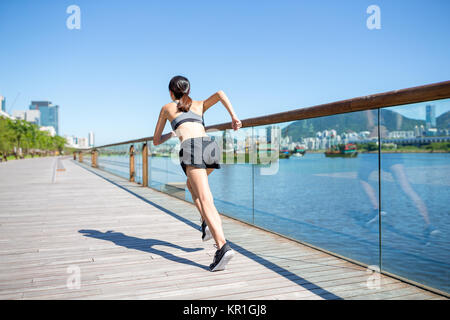 Back view of woman running on boardwalk Stock Photo