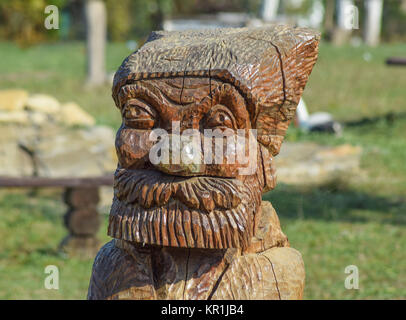 The face of a bearded old man carved out of logs Stock Photo