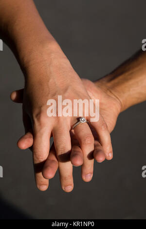 Engaged couple holding hands Stock Photo