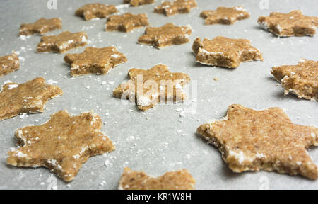Closeup of star shaped cinnamon cookies ready to be frosted - batch of traditional christmas cookies - Alsace, France. Stock Photo