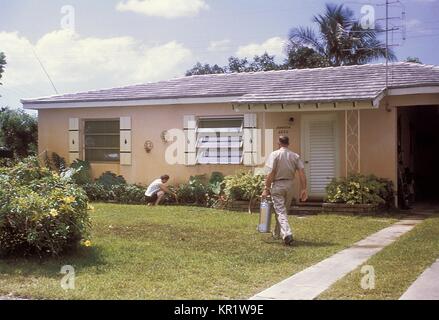 This photograph was taken during the 1965 Aedes Aegypti eradication program in Miami, Florida, 1965. In the 1960s, a major effort was made to eradicate the principal urban vector mosquito of dengue and yellow fever viruses, A. aegypti, from southeast United States, such as spraying for mosquitoes using a hand-held compressed air sprayer. Image courtesy CDC. Stock Photo