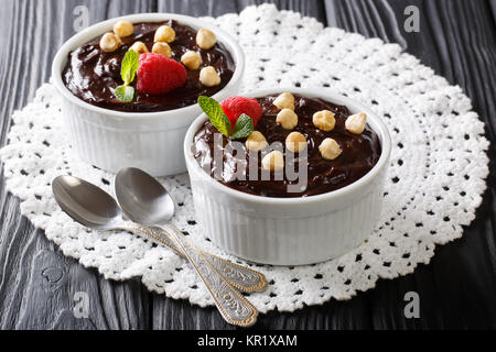 chocolate cream with hazelnuts, mint and raspberries close-up on the table. horizontal Stock Photo