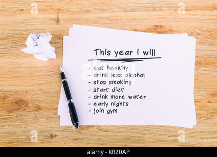 This year i will phrase written on paper with pen. Retro style wooden background. Stock Photo