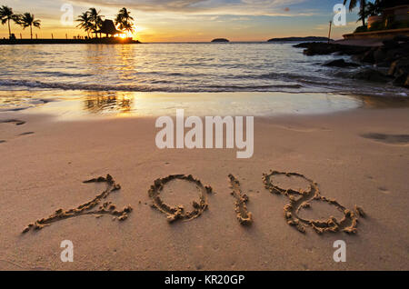 Number 2018 written on a sand beach during sunset. Stock Photo