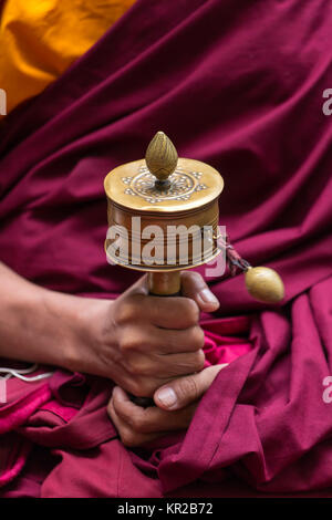 Tibetan prayer wheel in monks hands close-up Stock Photo