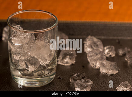 Empty Glass With Ice Cubes on Black Tray Stock Photo