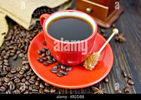 Coffee in red cup with sugar and bag on board Stock Photo