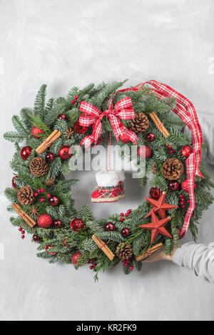 Beautiful Christmas wreath in woman hands. Preparation for holidays concept. Flower shop is a master work of a professional florist. Stock Photo