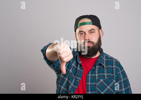 young bearded man with baseball cap with thumb down Stock Photo