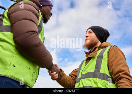 Workers Shaking Hands Outdoors Stock Photo