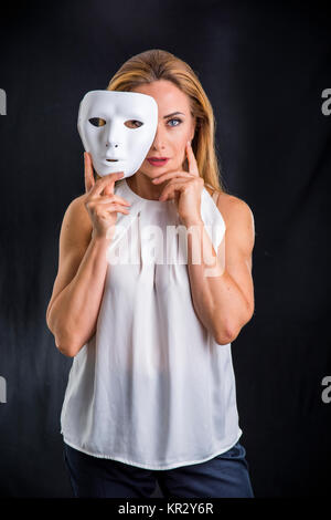 Woman holding theatre mask Stock Photo