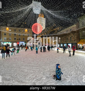 people skating on the ice rink in a town square in the center of Villach, Austria Stock Photo