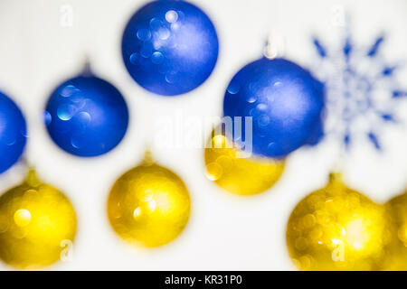 Christmas defocused festive background. New Year blurry blue and gold colors brilliant beautiful balls and snowflakes hanging on silver ropes isolated Stock Photo