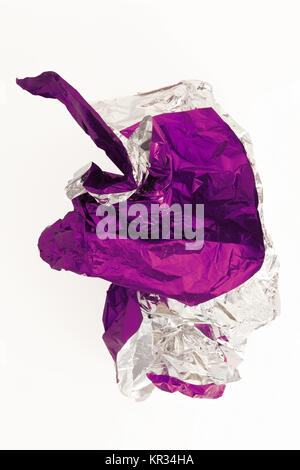 Crumpled wrapping paper ball falling on white surface. Stock Photo