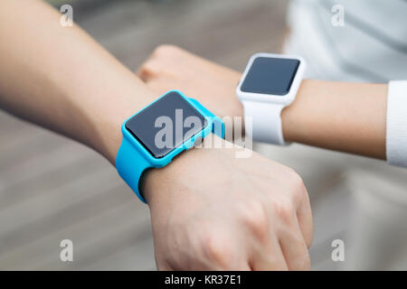 Couple comparing time on smart watch with other Stock Photo