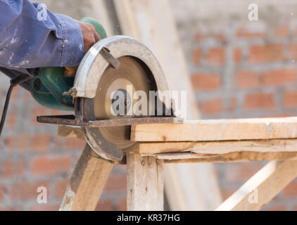 Carpenter using circular saw in loggers Stock Photo